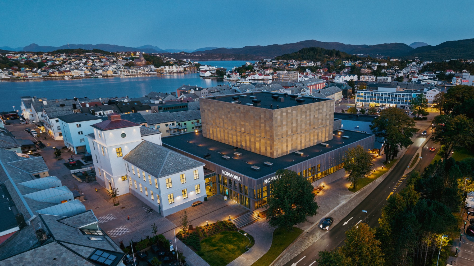 Normoria sett fra lufta i skumringen, med byen og fjorden rundt.